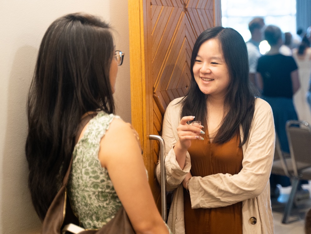 Two women talking and laughing after the Sunday service
